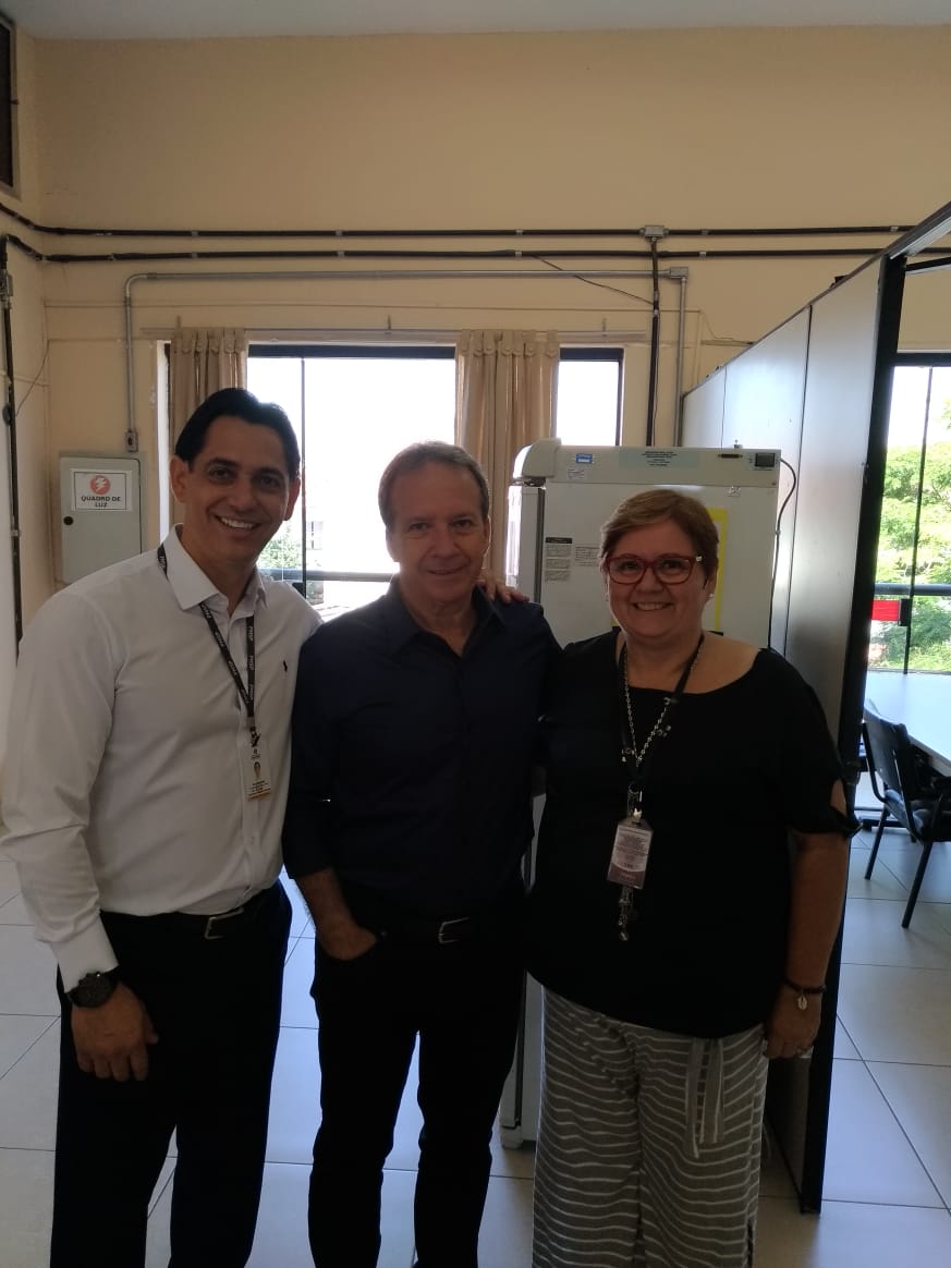 Imagem colorida, com o Secretário de Saúde, Edson Aparecido, no centro, no seu lado esquerdo está o Subprefeito Alexandre Pires, do lado direito do Secretário, está a Supervisora de Saúde do Jaçanã, Iara, os três estão sorrindo.